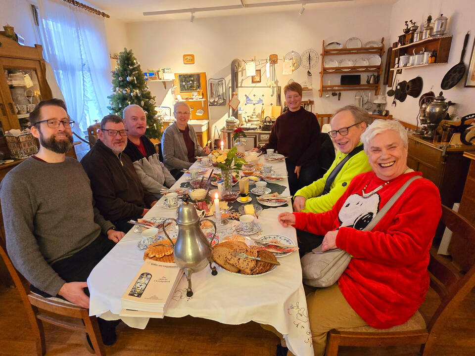 Die Gäste sitzen an einer Bergischen Kaffeetafel.